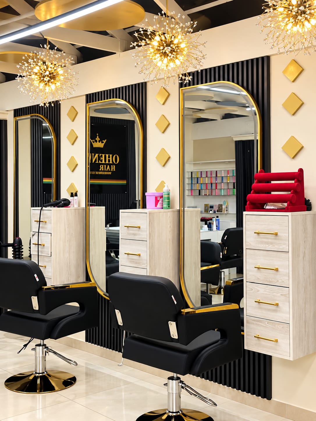 Inside Oheneba Hair Studio — gold arched mirrors, black styling chairs and crystal chandeliers
